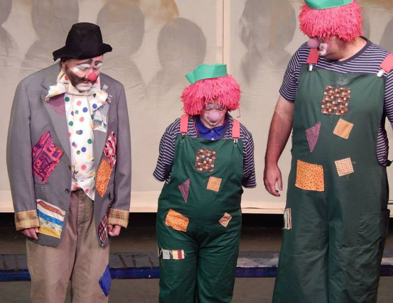 image of three people performing on stage as clowns